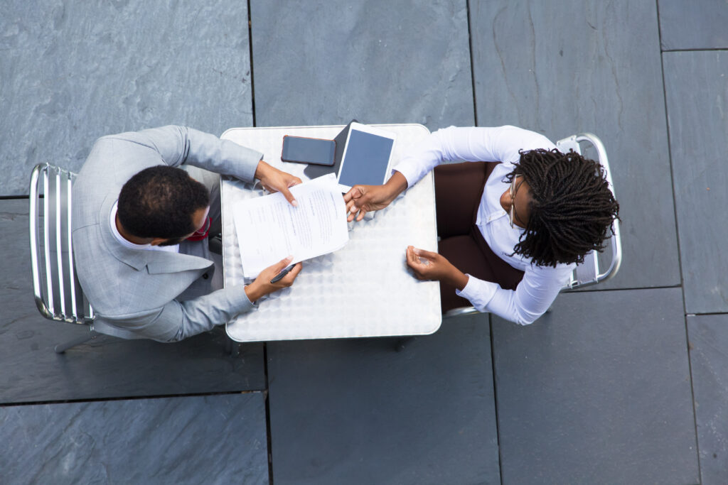 African American businesswoman passing documents to colleague