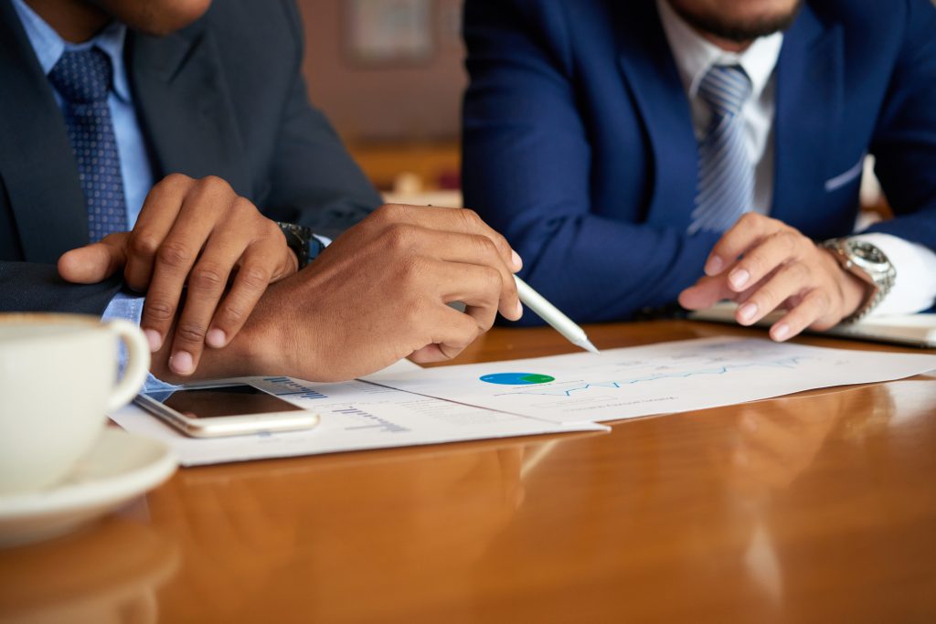 Close-up image of business people discussing financial data at meeting